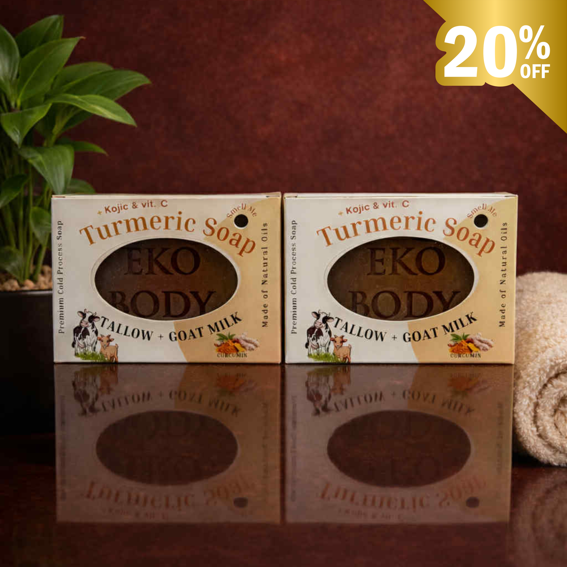 Two boxes of Eko Body Turmeric Soap on a reflective surface with a plant in the background.